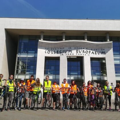 Zdjęcie grupowe z rowerami przed budynkiem Collegium Europaeum.