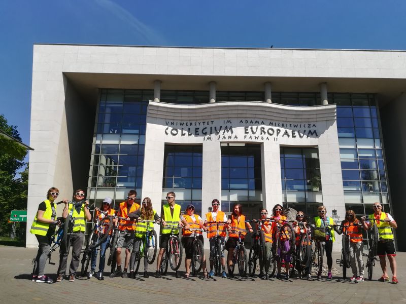 Zdjęcie grupowe z rowerami przed budynkiem Collegium Europaeum.
